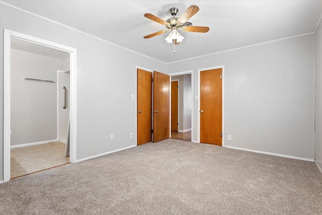 unfurnished bedroom featuring crown molding, light colored carpet, and ceiling fan