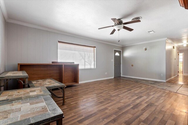 interior space with crown molding, ceiling fan, hardwood / wood-style flooring, and a textured ceiling