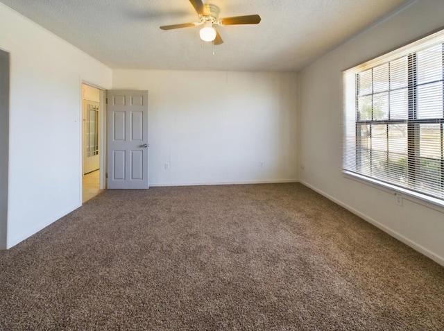 spare room featuring ceiling fan, a textured ceiling, and carpet