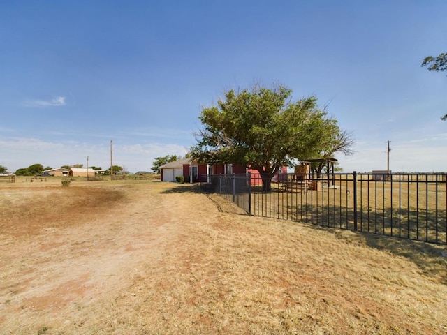 view of yard with a garage and a rural view