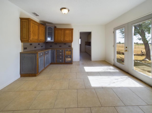 kitchen with tasteful backsplash, french doors, and light tile patterned floors