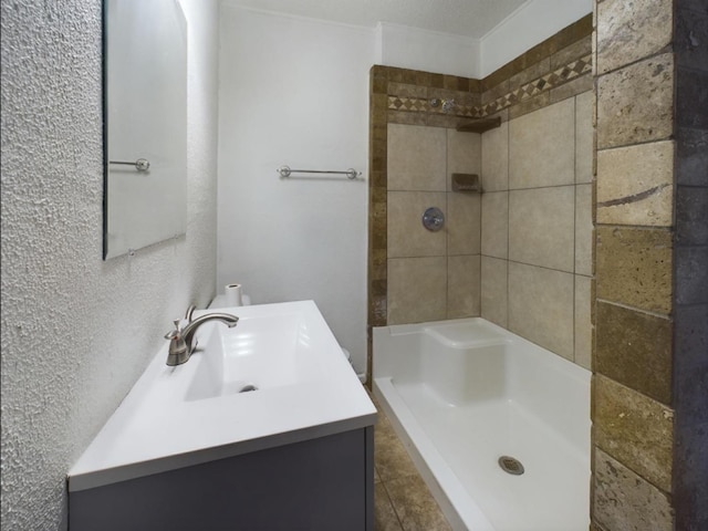 bathroom featuring vanity and tiled shower