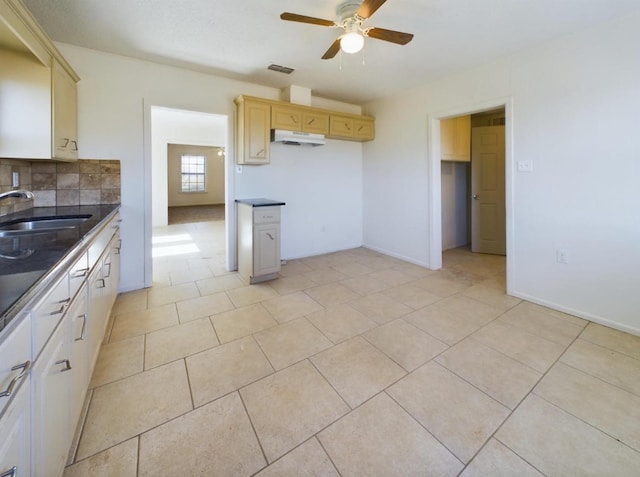 kitchen with sink, backsplash, light tile patterned floors, and ceiling fan