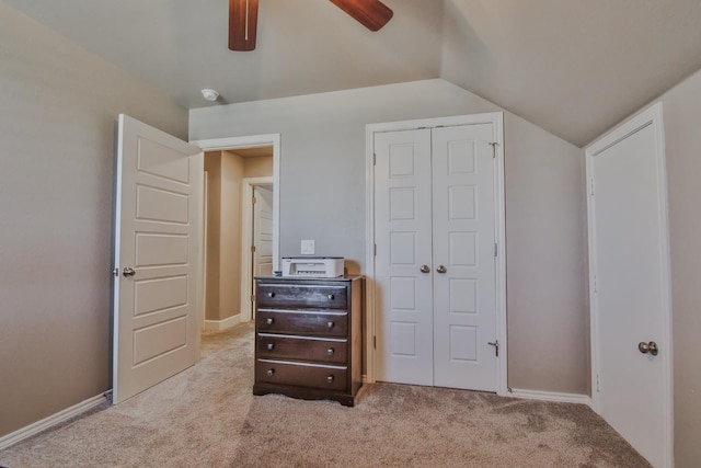 bedroom featuring vaulted ceiling, light carpet, ceiling fan, and a closet