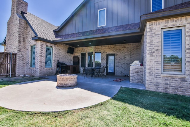 back of property featuring a patio, a lawn, and an outdoor fire pit