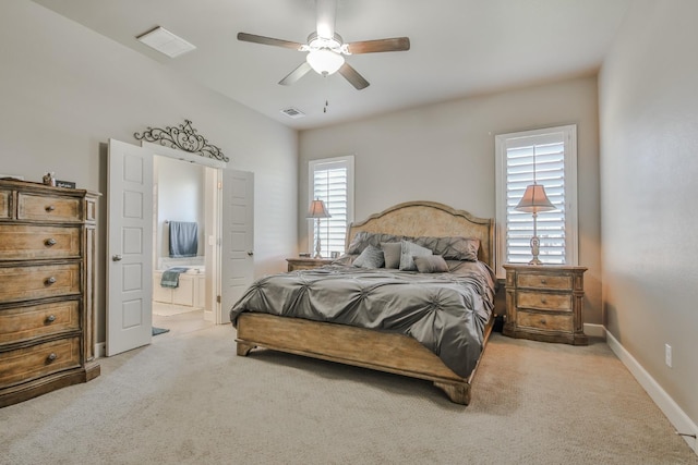 bedroom with ceiling fan, ensuite bathroom, and light carpet