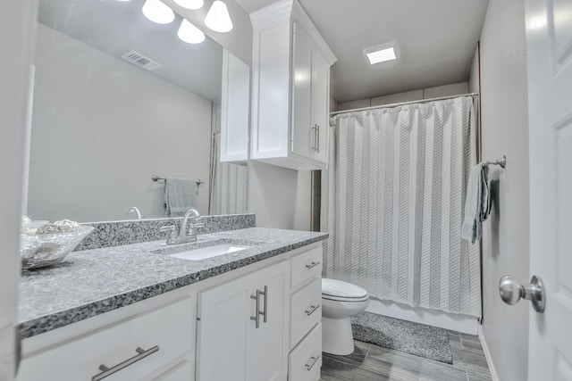 bathroom featuring vanity, a shower with shower curtain, and toilet