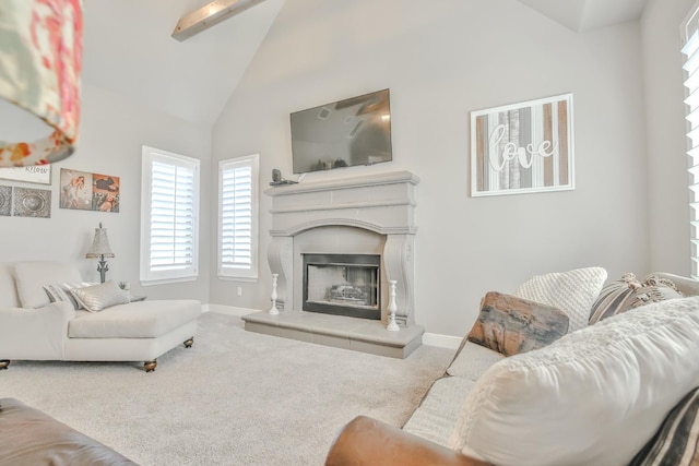 carpeted living room with a tile fireplace and high vaulted ceiling