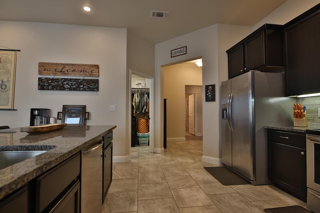 kitchen featuring dark stone countertops, baseboards, visible vents, decorative backsplash, and appliances with stainless steel finishes