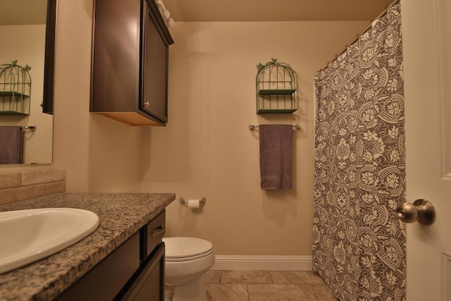 bathroom with vanity, toilet, a shower with curtain, and baseboards