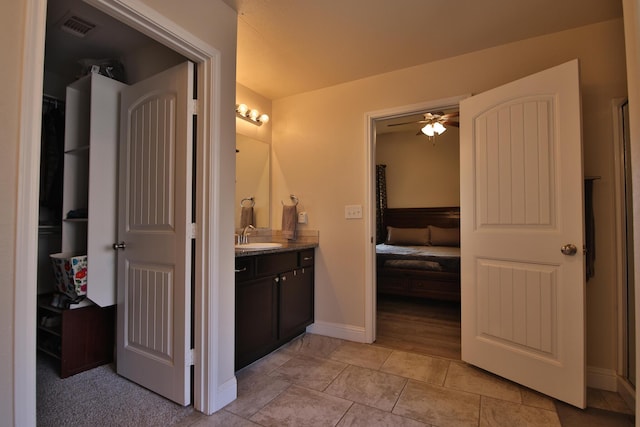 bathroom with visible vents, ensuite bathroom, a ceiling fan, baseboards, and vanity