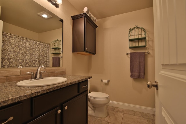 full bathroom featuring vanity, toilet, and baseboards