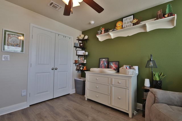 bedroom with dark wood finished floors, visible vents, a closet, and baseboards