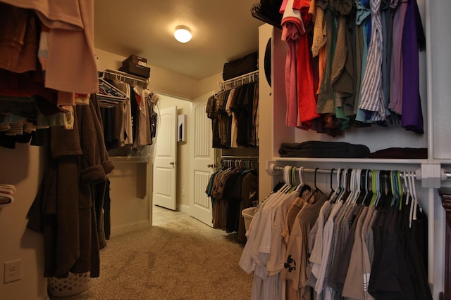 walk in closet featuring light carpet