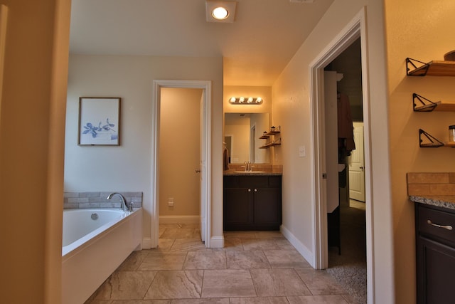 bathroom with baseboards, a bath, and vanity