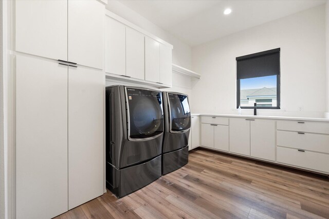 12001 Vicksburg Ave, Lubbock, TX 79424 - laundry room featuring washer and clothes dryer, light wood-style flooring, recessed lighting, and cabinet space
