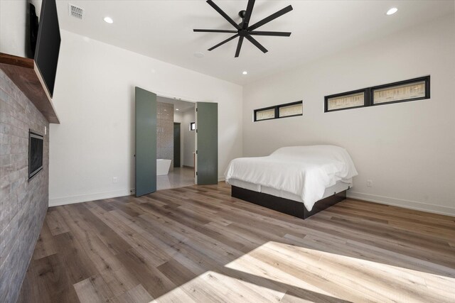12001 Vicksburg Ave, Lubbock, TX 79424 - bedroom featuring wood finished floors, recessed lighting, a glass covered fireplace, baseboards, and a ceiling fan