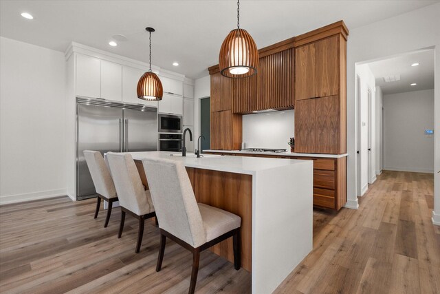 12001 Vicksburg Ave, Lubbock, TX 79424 - kitchen featuring modern cabinets, built in appliances, a sink, brown cabinets, and recessed lighting