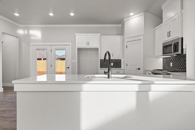 kitchen with crown molding, sink, decorative backsplash, and white cabinets