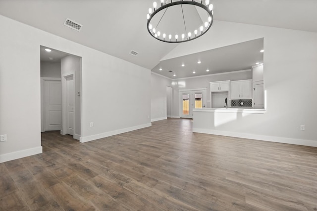 unfurnished living room with ornamental molding, dark hardwood / wood-style flooring, sink, and a notable chandelier