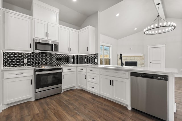 kitchen featuring dark hardwood / wood-style floors, white cabinetry, sink, hanging light fixtures, and stainless steel appliances