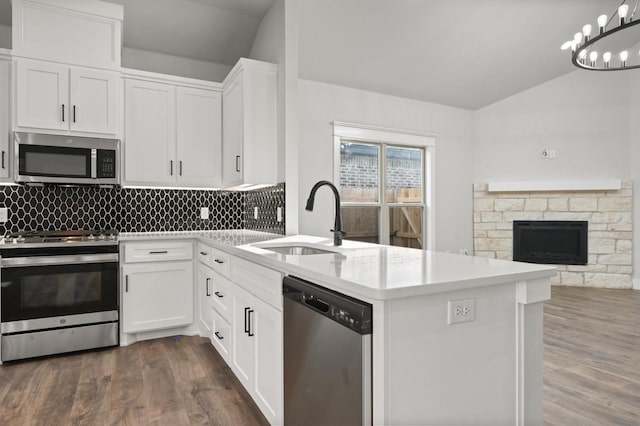 kitchen featuring lofted ceiling, appliances with stainless steel finishes, backsplash, white cabinets, and dark hardwood / wood-style flooring