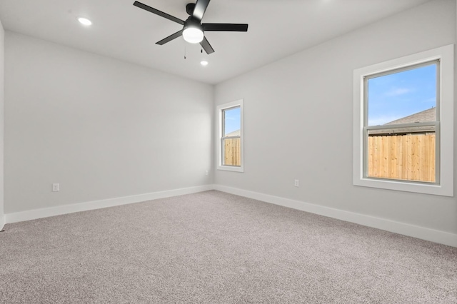 carpeted spare room with ceiling fan