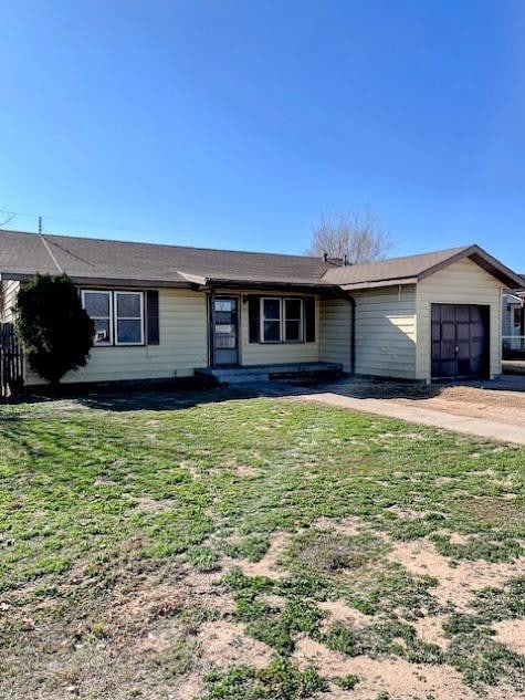 ranch-style house with a garage and a front yard