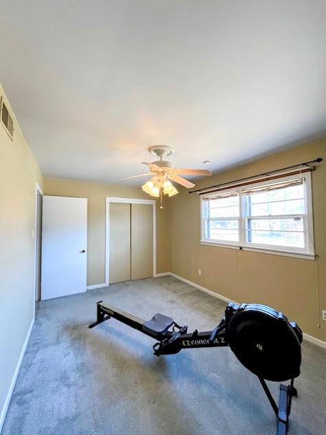 workout area with a ceiling fan, visible vents, baseboards, and carpet flooring