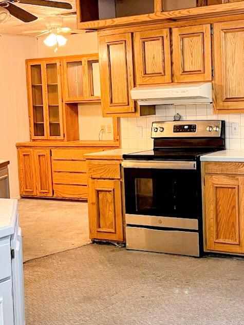 kitchen featuring light countertops, decorative backsplash, a ceiling fan, under cabinet range hood, and stainless steel electric range