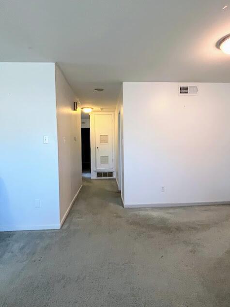 hall with baseboards and visible vents