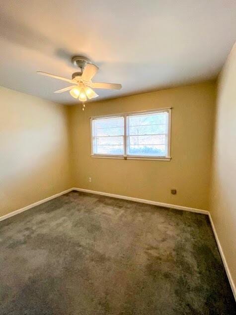 unfurnished room with ceiling fan, dark colored carpet, and baseboards