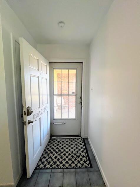 doorway featuring baseboards