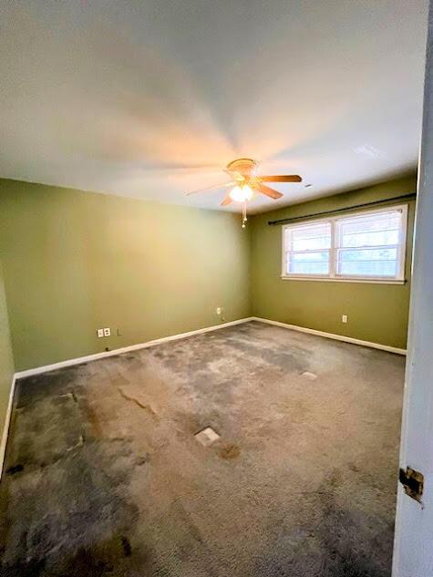 unfurnished room featuring carpet, ceiling fan, and baseboards