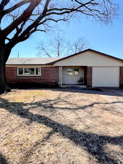 single story home with concrete driveway, brick siding, and an attached garage