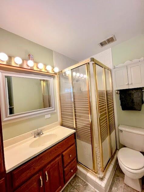 bathroom with toilet, vanity, visible vents, and a shower stall