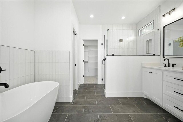 1406 Durham Ave, Wolfforth, TX 79382 - full bathroom with vanity, tiled shower, a freestanding bath, a walk in closet, and recessed lighting
