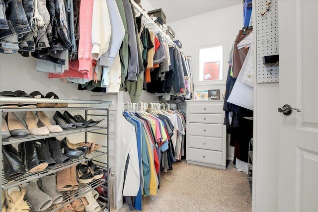 walk in closet featuring light carpet