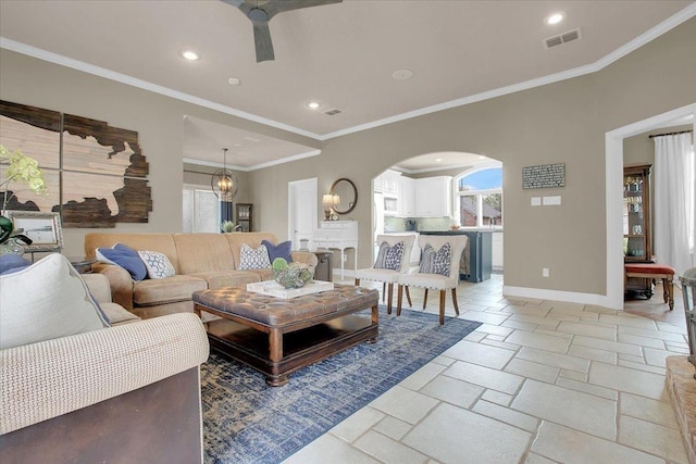 living room with ornamental molding and ceiling fan