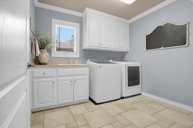 clothes washing area featuring cabinets, ornamental molding, sink, and washing machine and clothes dryer