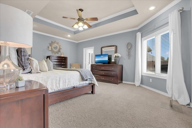 bedroom featuring ceiling fan, ornamental molding, a tray ceiling, and light carpet