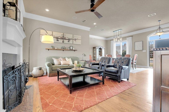 living room with crown molding, wood-type flooring, and ceiling fan with notable chandelier