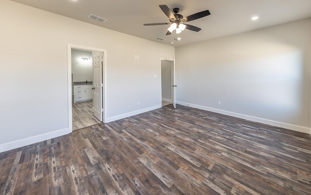 unfurnished bedroom with ceiling fan, connected bathroom, and dark hardwood / wood-style floors