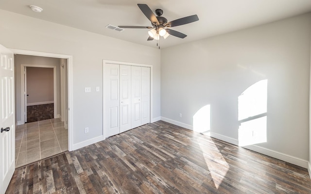 unfurnished bedroom featuring dark hardwood / wood-style flooring, a closet, and ceiling fan