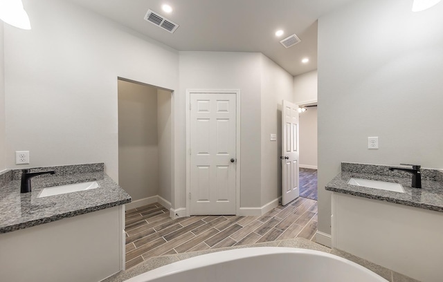 bathroom featuring vanity and a tub