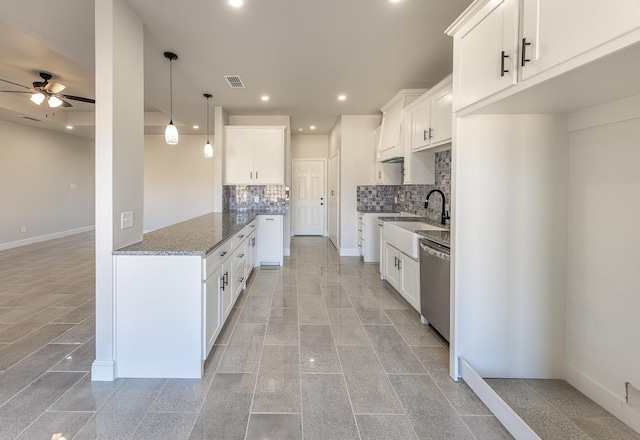 kitchen with sink, stainless steel dishwasher, white cabinets, and stone countertops