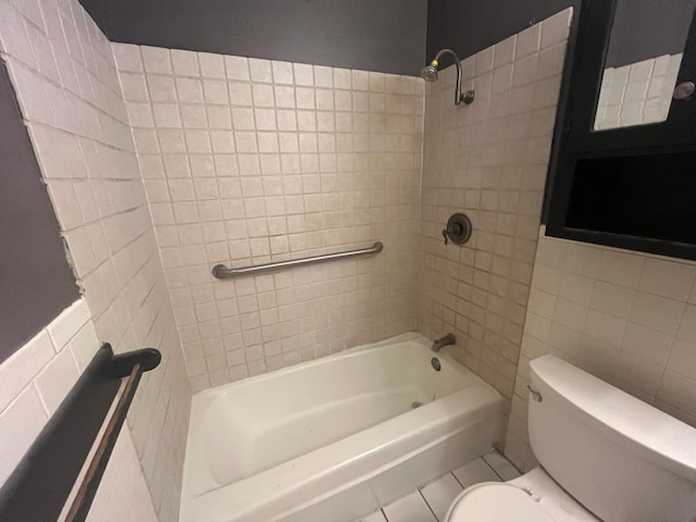 bathroom featuring tile walls, tiled shower / bath combo, and toilet