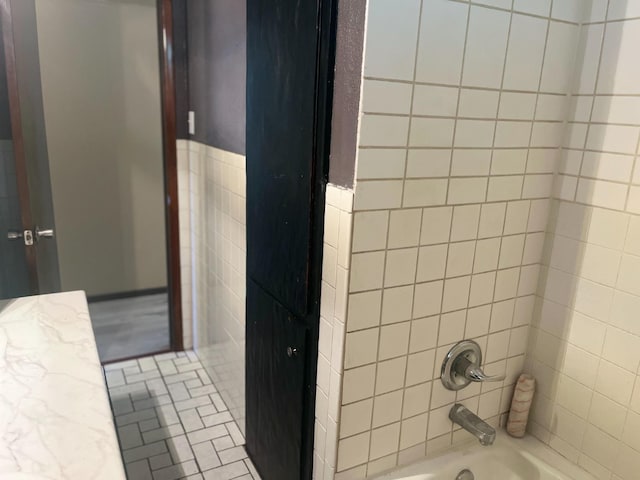 bathroom with tiled shower / bath combo and tile walls