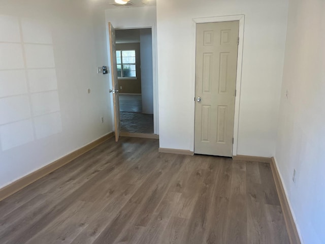 unfurnished room with dark hardwood / wood-style flooring