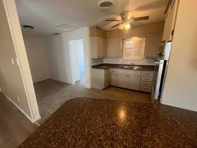 kitchen with ceiling fan, sink, and a textured ceiling